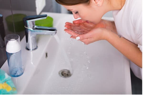 Image of woman washing her face.