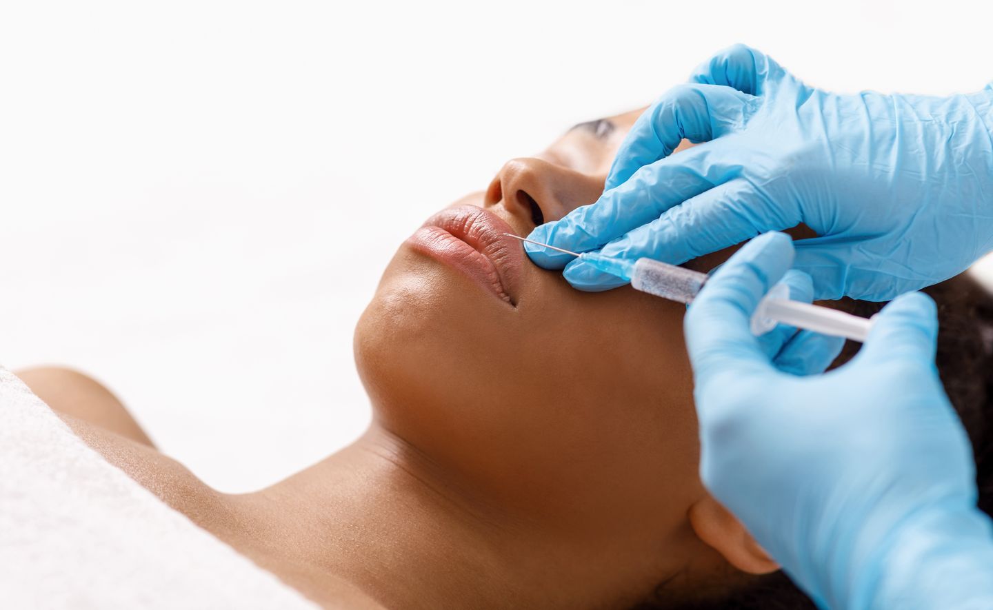 practitioner performing a Botox lip flip injection on a womans upper lip
